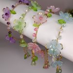 Handmade floral headbands in pastel colors displayed on white cylinder - Sakura, Lavender, Pistachio, Aqua